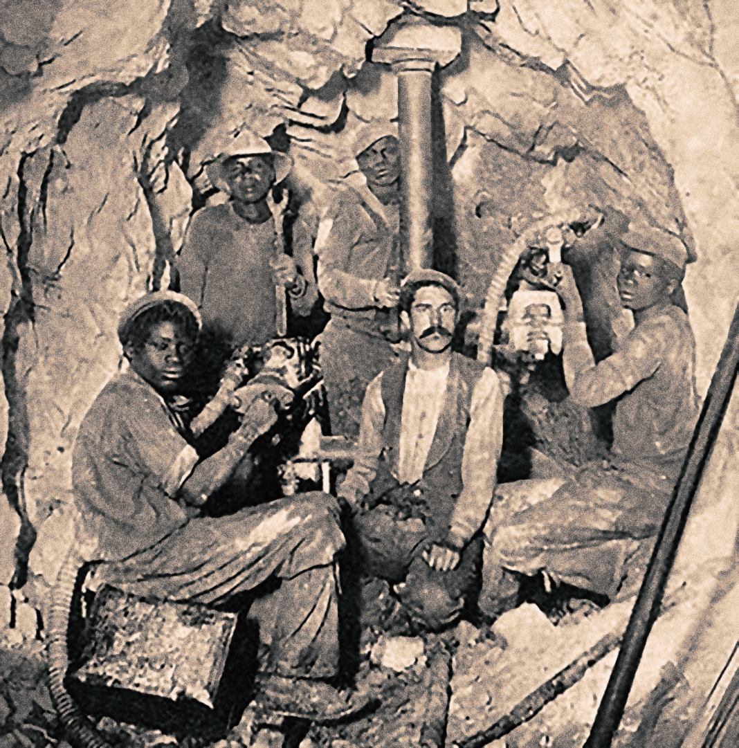 Fyra svarta och en vit arbetare i en guldgruva i Langlaagte nära Johannesburg, 1920-talet.